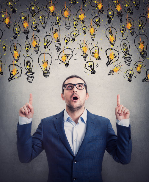 惊讶的商人伸出食指，看着头顶上漂浮的多个灯泡，他看起来很震惊。印象深刻的商业人士从不同的创意想法选择图片下载