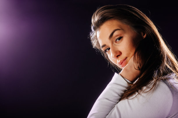 一个有吸引力的女孩的肖像，她的头发，而看起来英俊和满足。图片下载