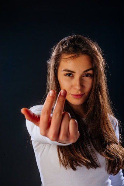 英俊的女模特指着你，而站在一个黑色的背景前图片下载