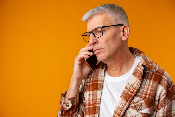 悲伤的欧洲男子在黄色背景下打电话的肖像图片下载