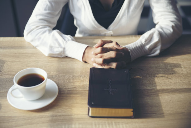 基督教的崇拜祈祷，并希望世界和平。由妇女手牵手，在教堂中信仰基督教。祈祷的概念。图片下载