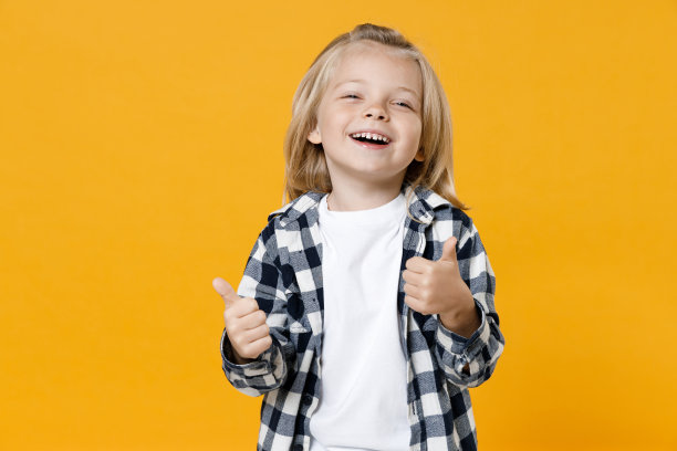 可爱有趣的小男孩，5岁，金发长发，穿着休闲服装摆姿势，孤立在明亮的黄色墙壁颜色背景的儿童画室肖像。人们的童年生活方式观念图片下载