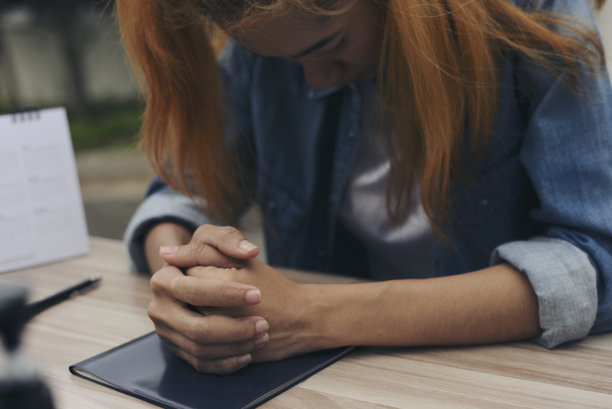 基督教的崇拜祈祷，并希望世界和平。由妇女手牵手，在教堂中信仰基督教。祈祷的概念。图片下载