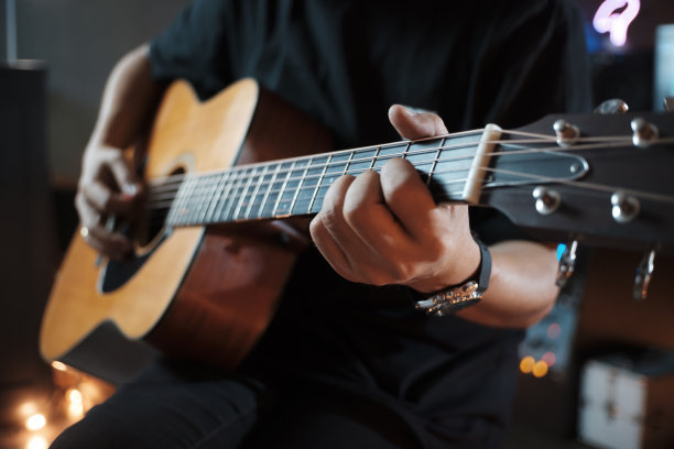 男人的手在弹奏原声吉他。图片下载