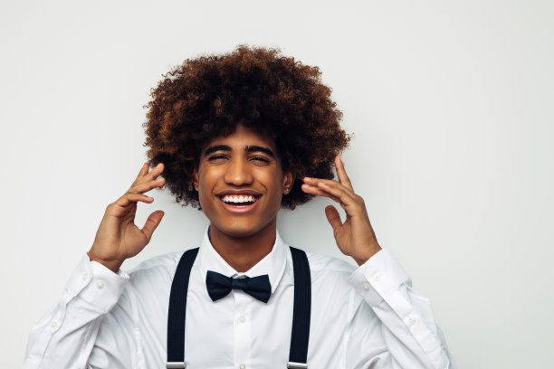 非洲裔美国人，留着非洲式发型，穿着白衬衫，站在孤立的白人背景上图片下载