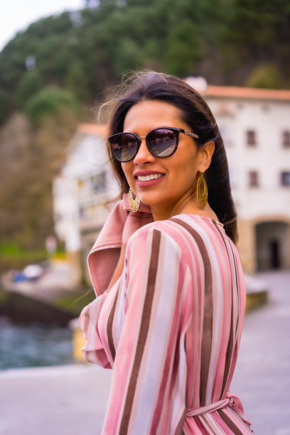 一个年轻的拉丁女人的肖像，在一个美丽的海滨小镇享受夏天的假期，在海边摆姿势，垂直的照片图片下载