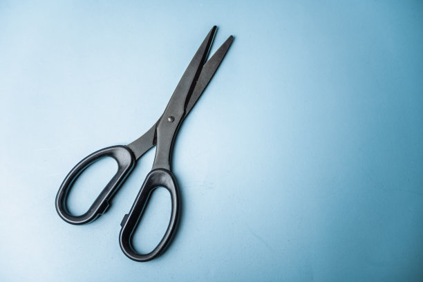 黑色剪刀在蓝色的背景图片下载