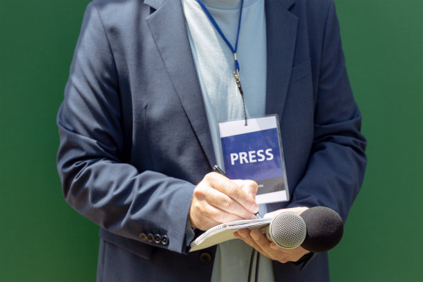 在新闻发布会上或媒体活动中持记者证的记者，手持麦克风，写笔记图片下载