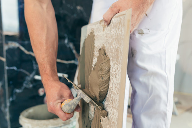 男职工专业用胶水用近抹刀在浴室贴瓷砖照片图片下载