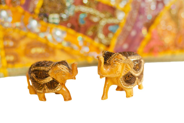 两个黄色和橙色的小印度象。背景上的黄色和橙色装饰。图片下载