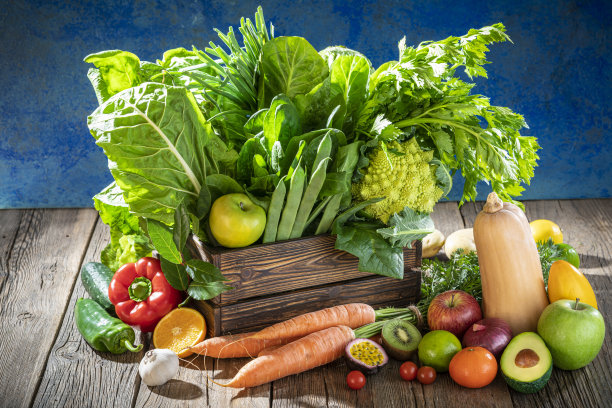 蓝墙上挂着收获后新鲜的木箱里的什锦水果和蔬菜图片下载