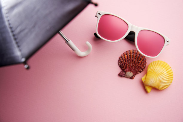 粉红色太阳镜和贝壳在伞的阴影下图片下载