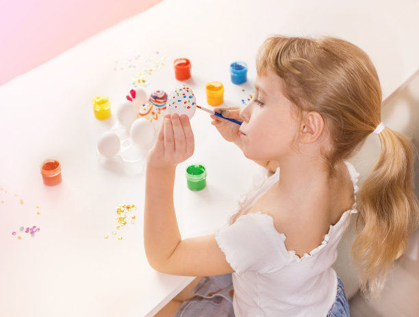 一个女孩正在装饰复活节彩蛋。图片下载