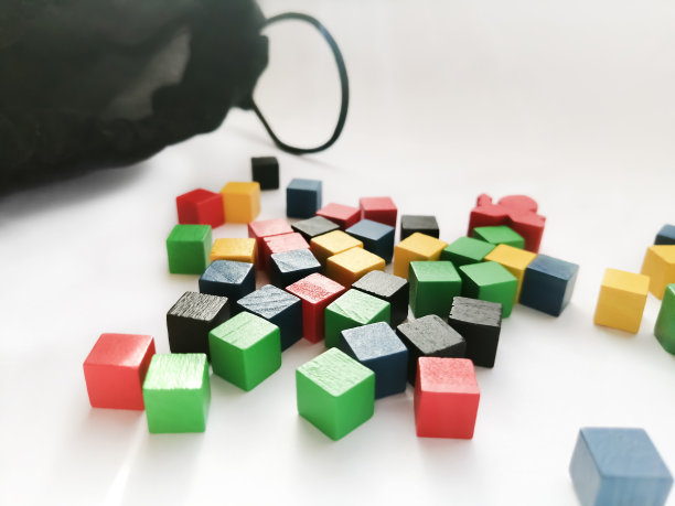 白色背景上的彩色木块。在它旁边是一个带烟的袋子。为儿童设置的建筑。图片下载