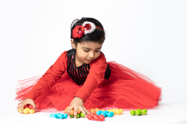 快乐的印度漂亮女孩玩彩色玩具在白色的背景。趣味，活动，教育，幼儿园，生日，学习，家庭活动，学校，托儿所，日托，发展理念图片下载