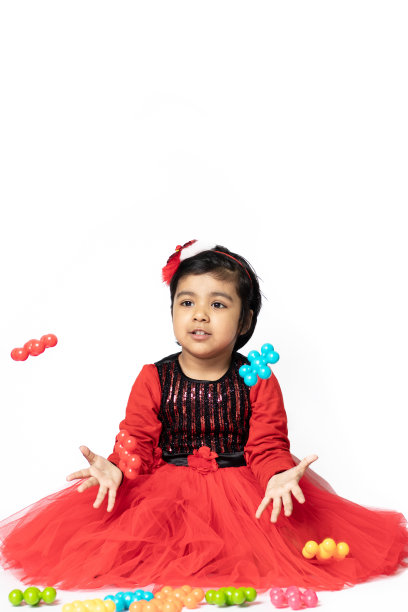 快乐的印度漂亮女孩玩彩色玩具在白色的背景。趣味，活动，教育，幼儿园，生日，学习，家庭活动，学校，托儿所，日托，发展理念图片下载