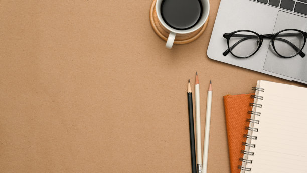 最简单的办公桌与文具和复印空间在棕色背景。图片下载