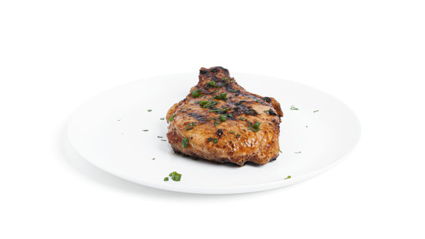 酱汁猪肉排放在盘子上，白色背景图片下载