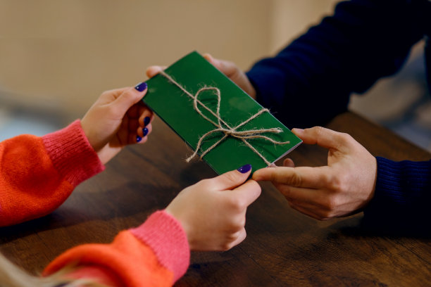 男人和女孩在咖啡馆喝咖啡，男人给了女孩一个绿色的信封，里面装着惊喜，女人很幸福，一对情侣相爱了图片下载
