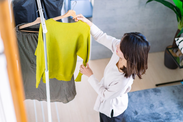 年轻女子在家挑选衣服图片下载