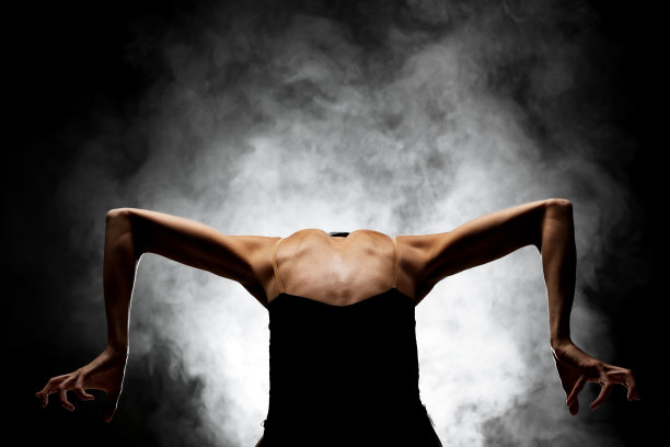 半剪影现代芭蕾舞演员摆姿势在黑暗的背景与烟雾图片下载