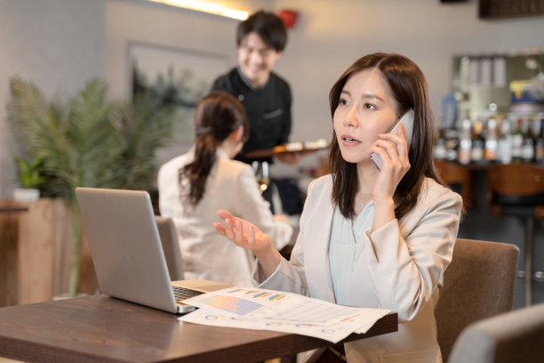 在餐馆用电脑进行远程工作的女人图片下载
