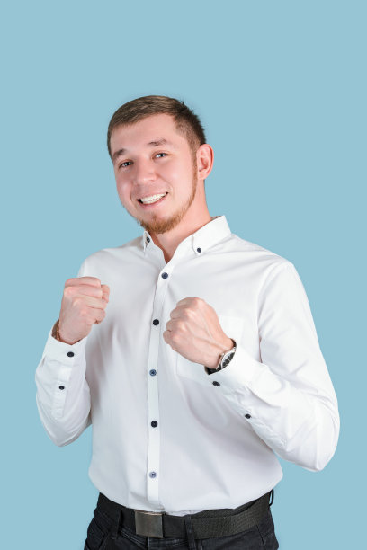 身穿白衬衫的经理双手紧握，站在一张以蓝色为背景的垂直照片上图片下载