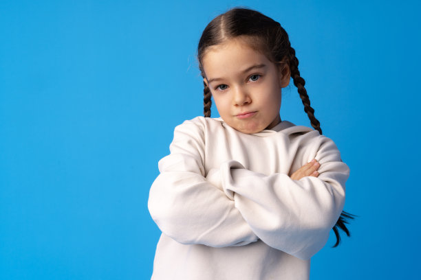 沮丧的小女孩在蓝色背景的肖像图片下载