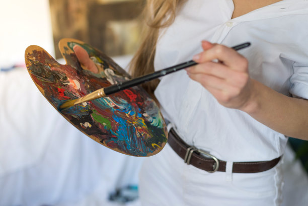 近距离拍摄女性艺术家绘画在家里，库存照片图片下载