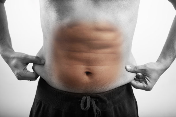 白色背景下显示腹部脂肪的男人图片下载