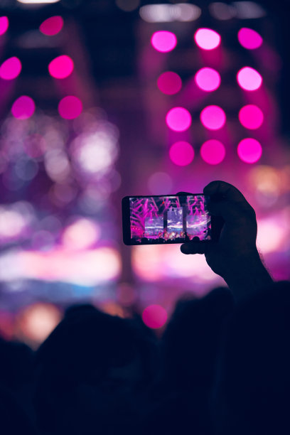 音乐会上手持智能手机的人。图片下载