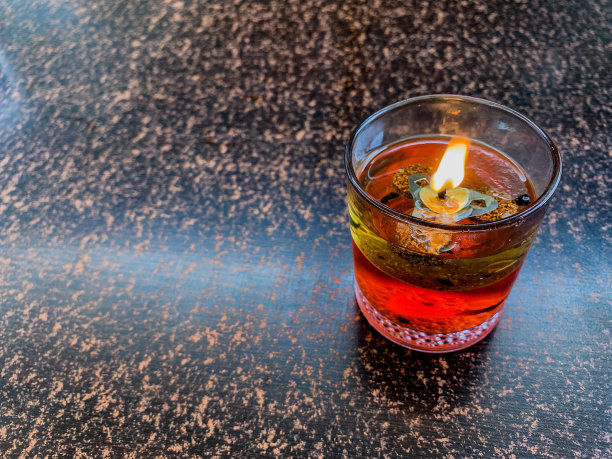 由灯芯和食用油制成的点燃的漂浮蜡烛图片下载