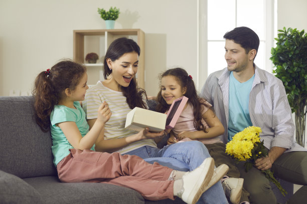 惊喜的妈妈带着开心的表情打开孩子们的礼物盒图片下载