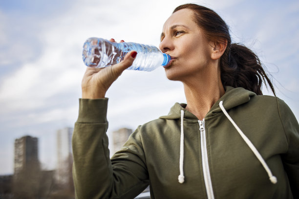 女运动员在桥上喝水，休息一下图片下载