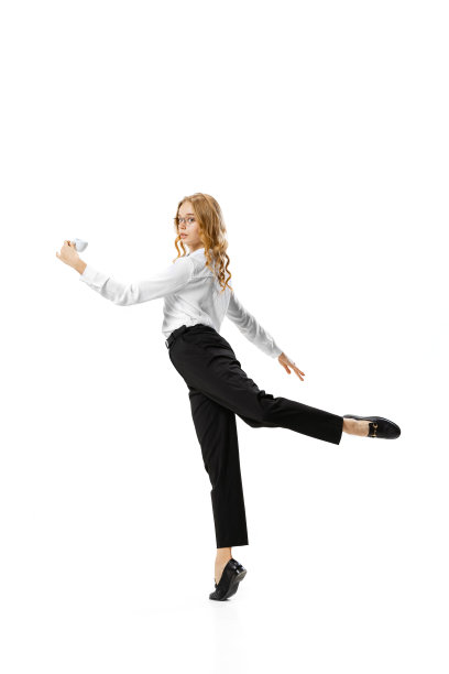 工作室拍摄的年轻苗条的女孩在商业风格的服装在行动，运动孤立在白色背景。金融、芭蕾、艺术、商业、美容、时尚理念。图片下载