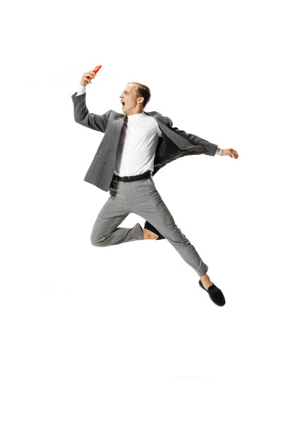 一个穿着灰色西装的年轻人在白色的背景上跳舞、跳跃、飞翔。商业，艺术，运动，行动，创意，灵感的概念。图片下载