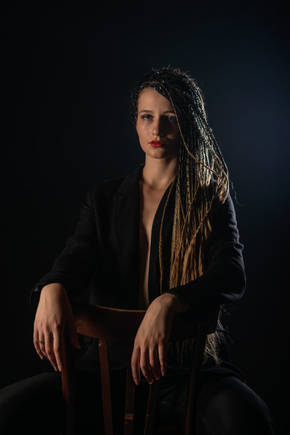 孤立的肖像在黑色背景与辫子的神秘女孩。图片下载