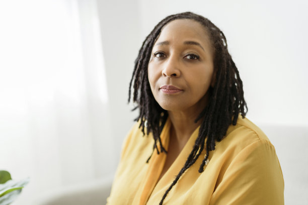 一名非洲妇女的肖像坐在沙发上，神情忧虑图片下载