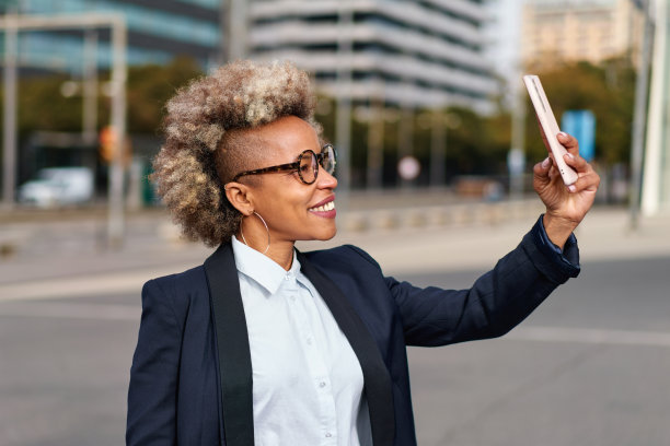 美丽的黑人女商人的肖像穿着西装在城市背景。非洲式发型的时尚模特。图片下载