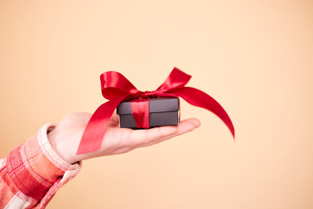 男性手中礼物盒的特写照片。拿着礼品盒的男人。情人节。生日或节日的概念。本空间图片下载