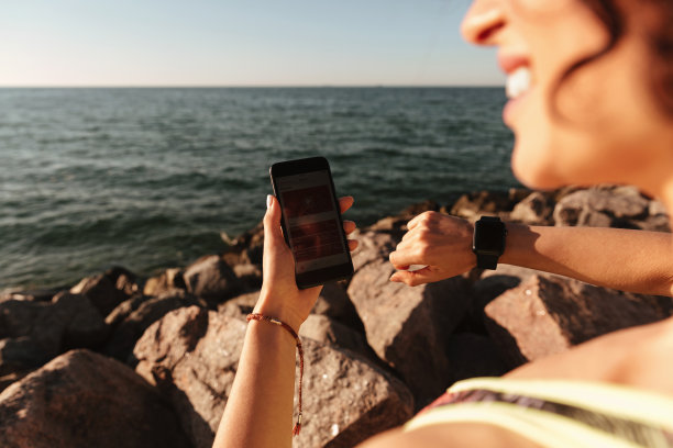 裁剪照片的年轻健身妇女设置她的智能手表图片下载