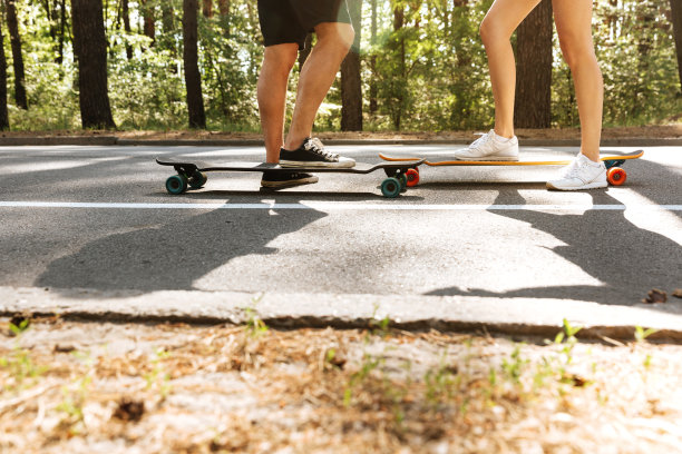 在滑板上的年轻的爱的夫妇裁切的形象。图片下载