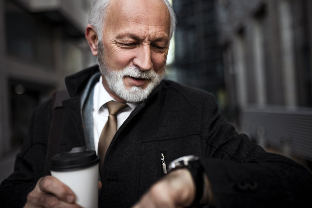 高级商人去办公室检查时间的特写肖像图片下载