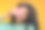 工作室的特写镜头开朗的微笑有吸引力的年轻女子覆盖了她的一部分脸与粉红色非洲菊花，孤立在黄色的背景图片下载