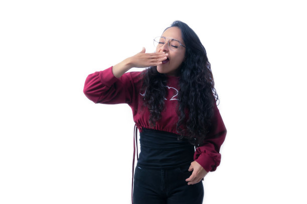 漂亮的拉丁裔西班牙裔妇女，长着浓密的头发，戴着眼镜在白色的背景下，在室内做表情和手势，疲倦，打哈欠，张开嘴，渲染，用一只手捂住嘴图片下载