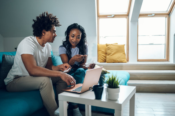 一对非裔美国夫妇在理财时使用笔记本电脑和信用卡图片下载