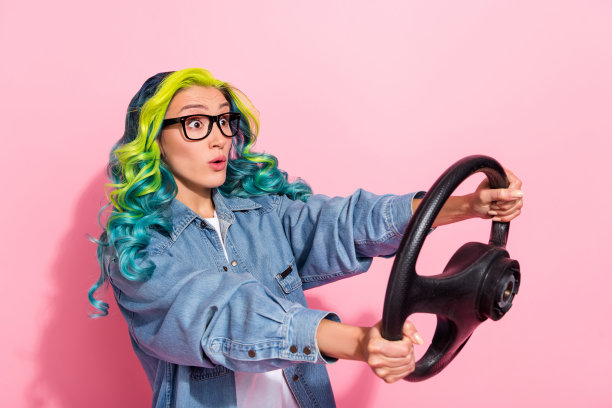 照片震惊漂亮年轻充满活力的女人穿牛仔裤衬衫眼镜上升汽车看空空间孤立的粉红色背景图片下载