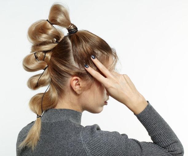 有创意的辫子发型的金发女性的背面肖像。图片下载