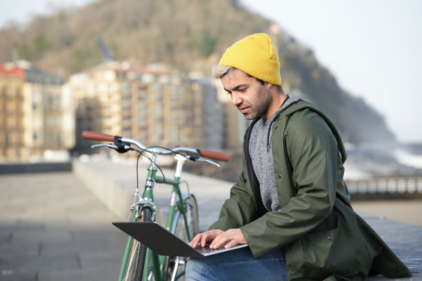 在自行车旁工作的西班牙裔自由职业者图片下载