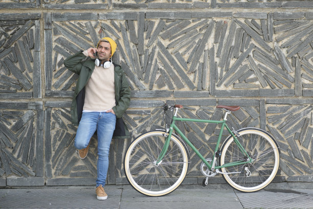 一个西班牙裔男人靠墙打电话图片下载